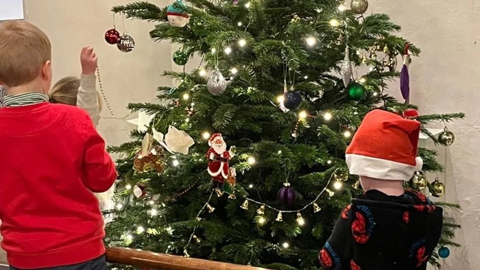Two children decorating Christmas tree.