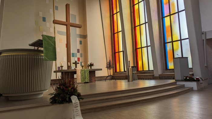 Die Kirche mit farbenfrohen Fenstern und einem großen Kreuz.