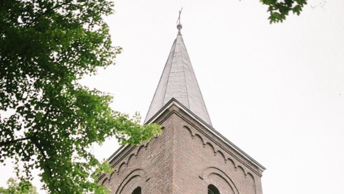 Der Kirchturm aus Ziegeln ragt hoch in den Himmel