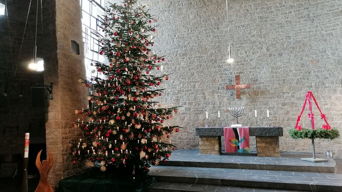 Weihnachtsbaum in der Kirche mit Krippenszene und Kerzen