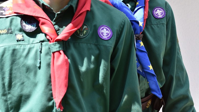 To skygge, to børn i grønne scoutjakker med skarver.