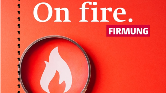 Ein Vergrößerungsglas zeigt auf ein Feuer-Symbol vor einem roten Hintergrund mit dem Text 