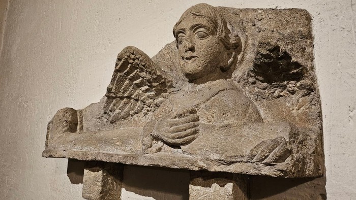Steinernes Relief eines schlafenden Engels an einer Wand