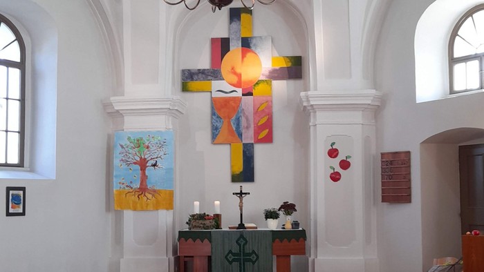In der Kirche hängen farbenfrohe Kreuz und Kronleuchter
