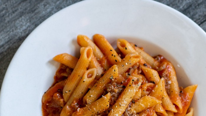 En bolle med penne med tomat sauce og ost