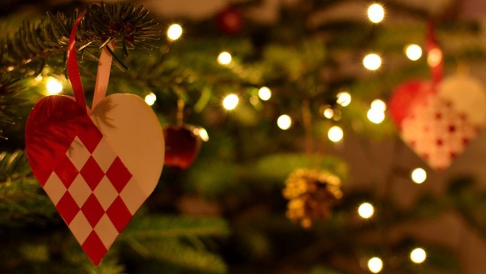En juledekoreret christmas tree med lys og hjerteformet pynt