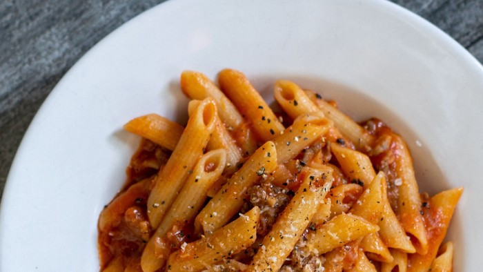 En bolle med penne med tomat sauce og ost