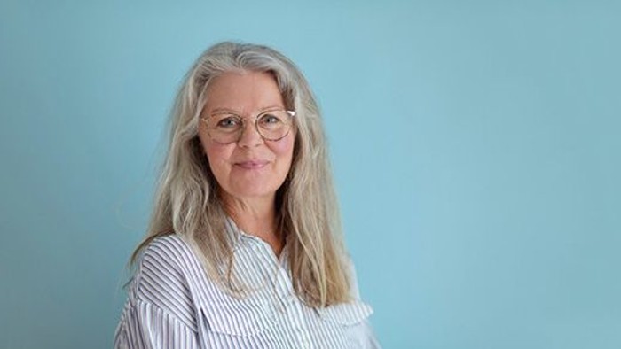 Kvinde med briller og blå baggrund