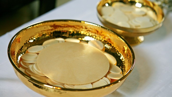 Goldene Zeremonialschalen enthalten Hostien und einen Kelch, die wahrscheinlich für religiöse Kommunionsrituale verwendet wurden.