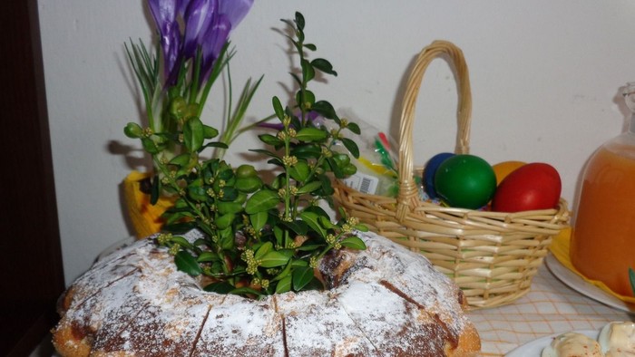 Der Kuchen ist mit Puderzucker bestäubt und mit einer grünen Pflanze dekoriert.