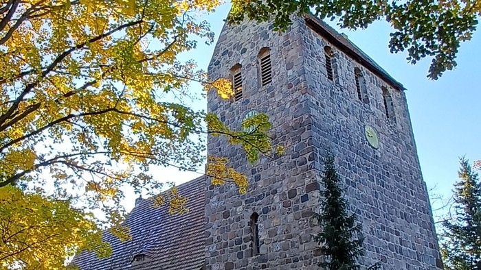 Dorfkirche Marienfelde umgeben von Bäumen mit Herbstlaub