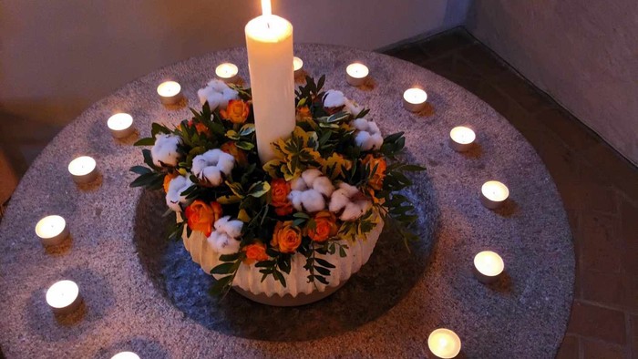 En rund bord med lys og blomster i midten