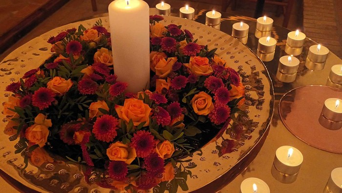 En stolt blomsterstok med lysende lys omgivet af flere lysede lygter.