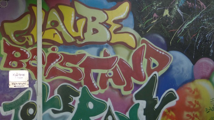 Buntes Graffiti-Wandbild mit lebendigen Graffiti-Schriftzügen und Blasen-Illustrationen an einer Wand.