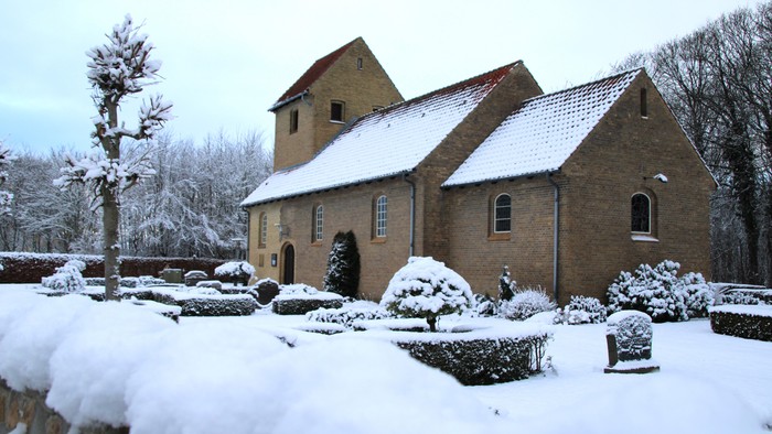 En snedækket kirke med smukke omgivelser