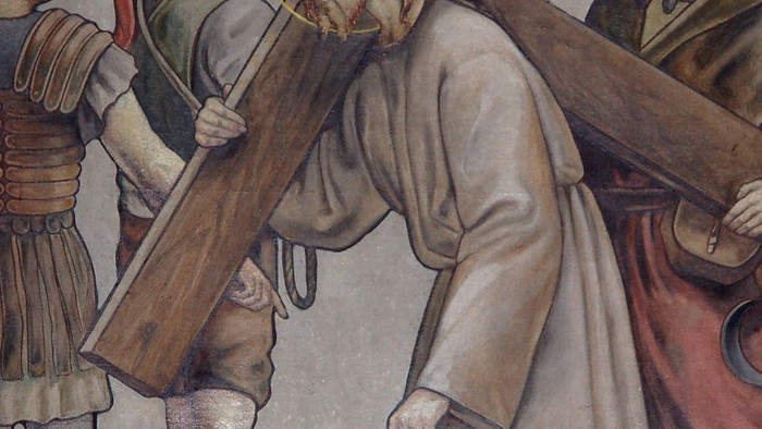 Jesus trägt das Kreuz, begleitet von zwei Männern und einer Frau.