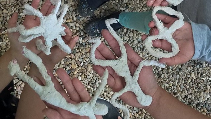 Kinder zeigen selbstgemachte Tonfiguren