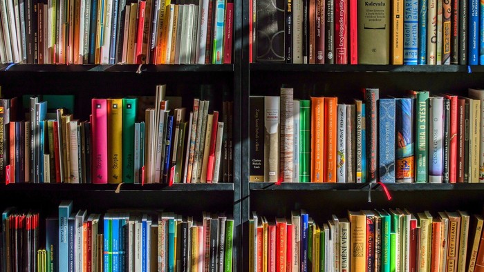 Bunte Bücherregale mit vielen Büchern verschiedener Farben und Größen.
