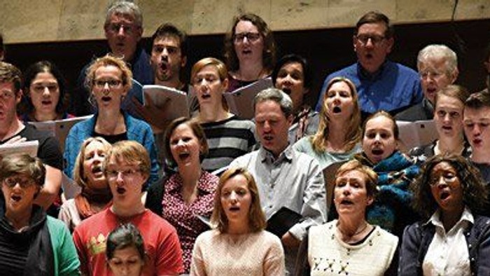 Eine große Gruppe von Menschen singt in einem Chor.