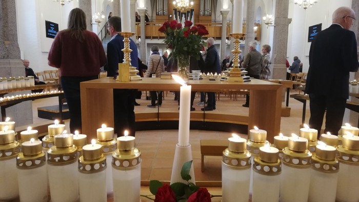 Ildstæder og røde roser i kirke.