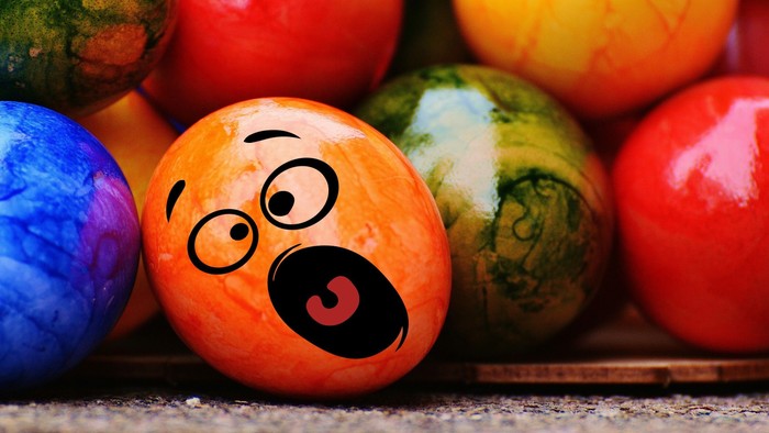 Bunte Eier. Das vorderste Ei ist mit einem Gesicht bemalt. Der Mund des Eies ist offen und sieht aus, als ob es schreien würde.