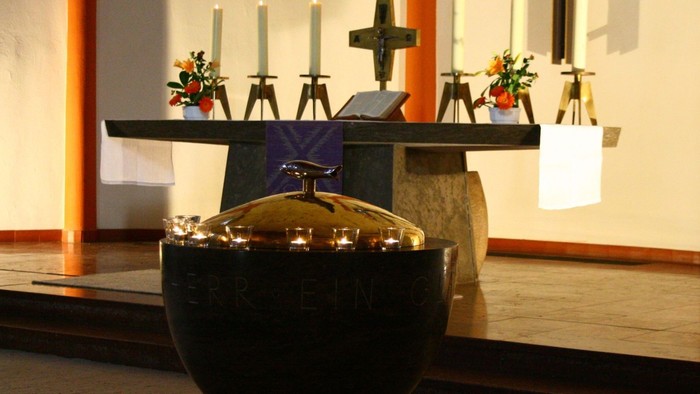 Ein Altar in einer Kirche mit Kerzen, Blumen und einem Kruzifix
