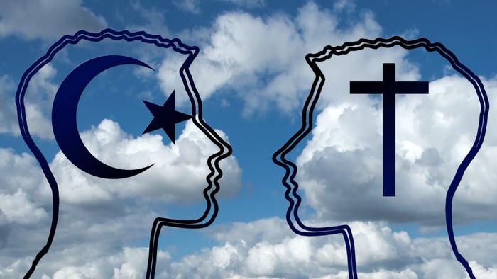 Zwei silhouettierte Köpfe, die den islamischen Halbmond-Stern und das christliche Kreuz symbolisieren, vor einem bewölkten Himmel.