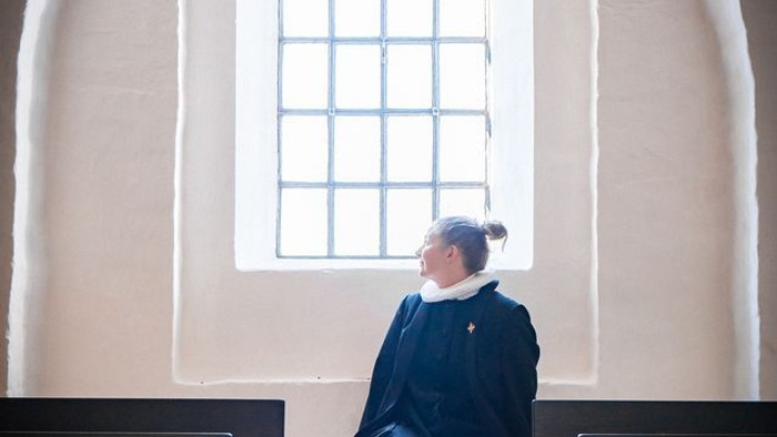 Portræt af sognepræst Cecilie Raaberg i lysindfald fra vindue i Sdr. Asmindrup Kirke