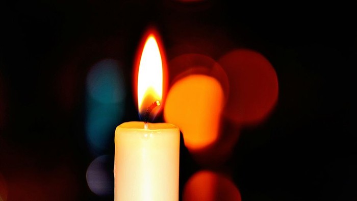 Brennende Kerze, orangene Lichtpunkte