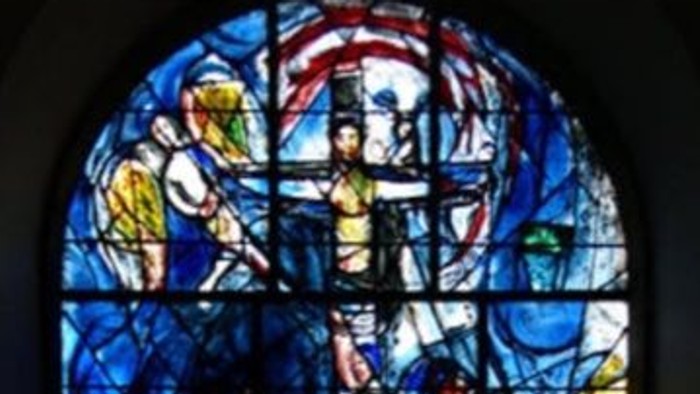 Stained glass window with religious figures, displayed on a smartphone screen