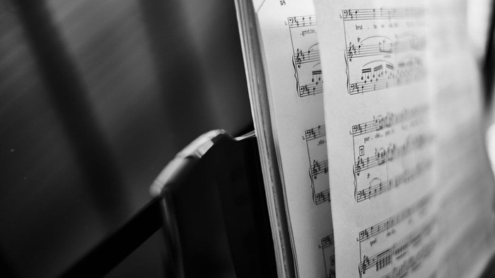 Ein Notenblatt mit Musiknoten und einem Stift.