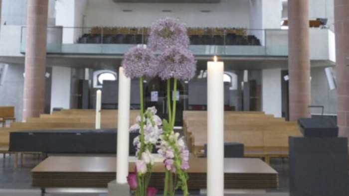Elegante Blumendekoration mit Kerzen in einer modernen, geräumigen Indoor-Kapelle.