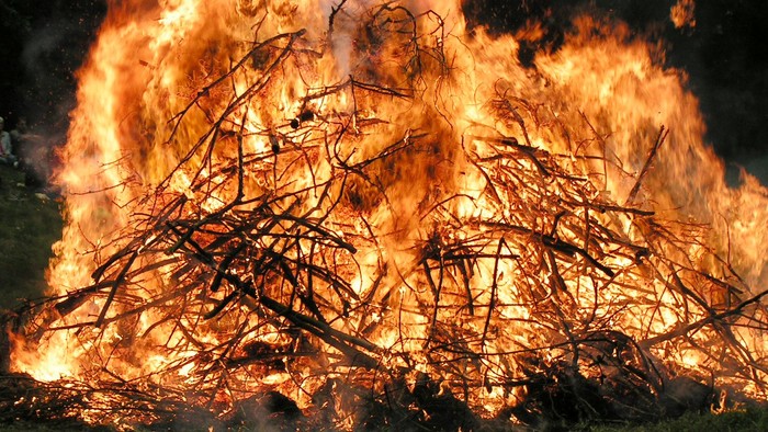 En stor bål flammer klart med tykke, knitrende flammer, der fortærer en stabel brænde.