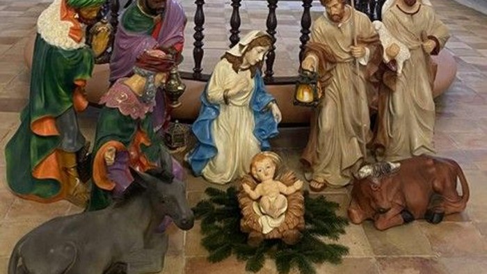 Julekrybbe. Figurer af Jesusbarnet i krybbe, Maria i hvid kjole og blå kappe kæler ved siden af ham. Dyr omkring