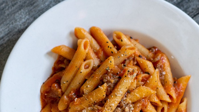 En bolle med penne med tomat sauce og ost