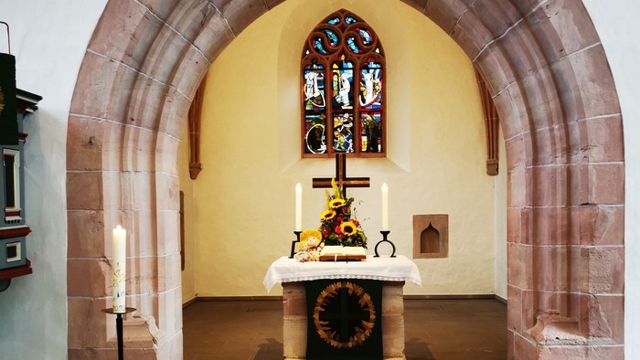 Gotteshaus mit Altar und Buntglasfenster