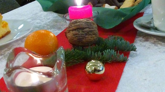 Weihnachtlicher Tisch mit Kerze, Gebäck und Dekoration