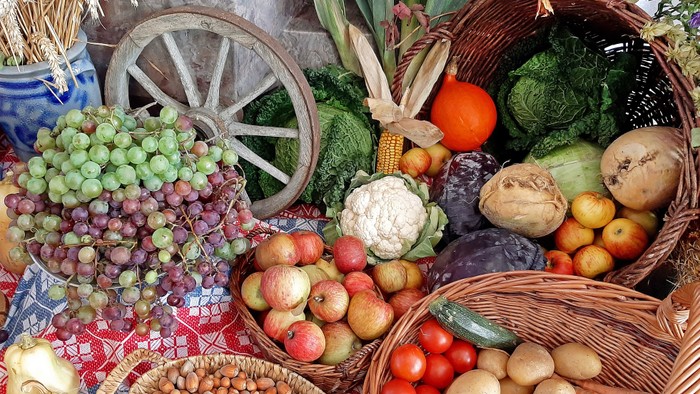 Verschiedene Obst- und Gemüsesorten in Körben und auf Tüchern arrangiert