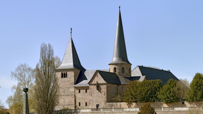 Historische Steinburg mit Zwillingstürmen und befestigten Mauern in einem gestalteten Innenhof.