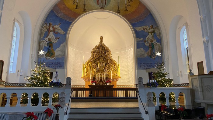 Indre del af kirke med alter og juletræer