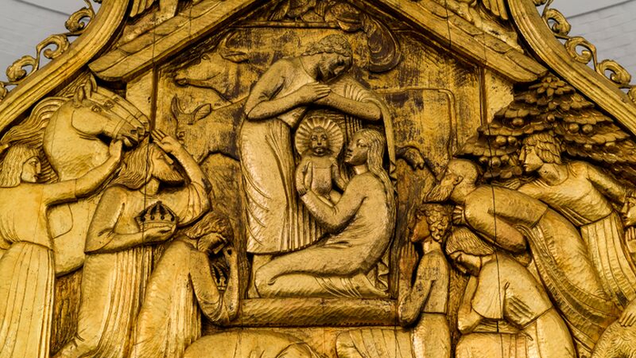 Detaljeret udsnit af en gotisk skånselindning med religiøse motiv.