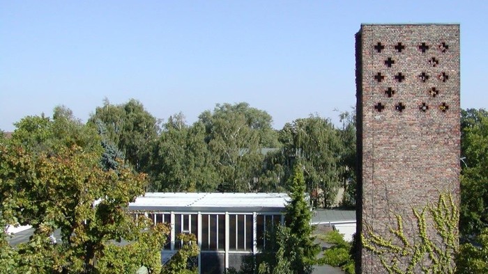 Ein Ziegelkamin und ein Pavillon in einem grünen Garten