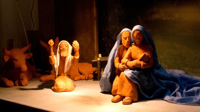 Eine Krippe mit Figuren, darunter Maria, Josef und das Jesuskind, in einer Nische.