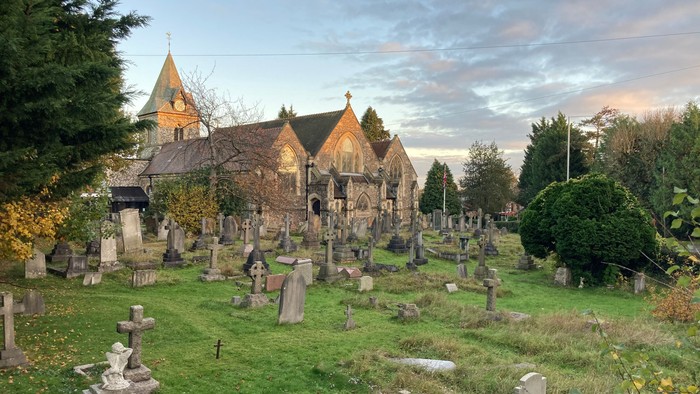 Churchyard with numerous gravestones and a historic church building.