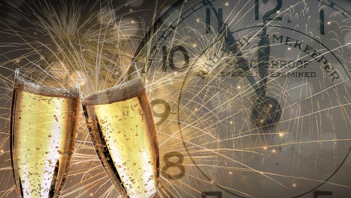 Toast med champagneglas og fyrværkeri ved nyårsaften