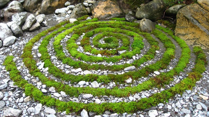 Ein spiralförmiger Moosgarten inmitten von Steinen und Felsen
