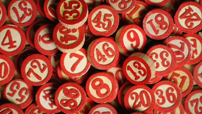 En masse røde bingo-marker med hvide numre.