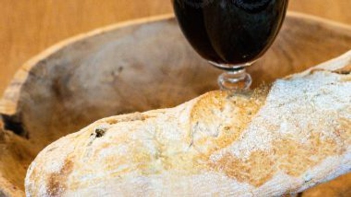 Foto: Baguette in Holzschüssel und Glas mit Rotwein