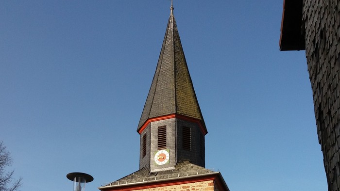 Steinerne Kirche mit hohem Turm und Uhr.
