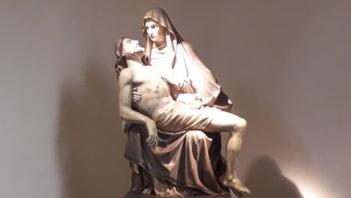 Die Statue zeigt eine sitzende Frau mit Kind auf dem Arm.